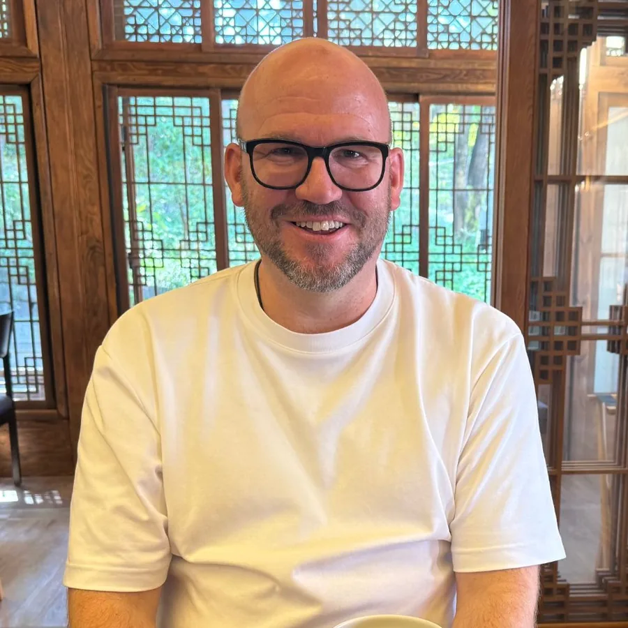 Pater Andy unterwegs, lachend am Tisch